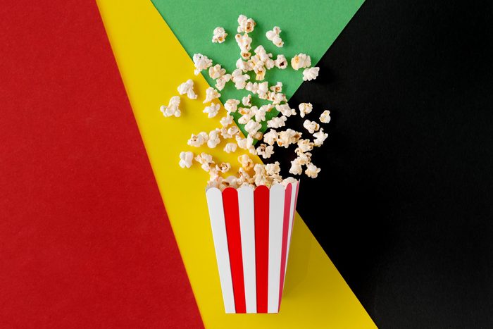 movie popcorn spilled out on a red, yellow, green, and black background for black history month