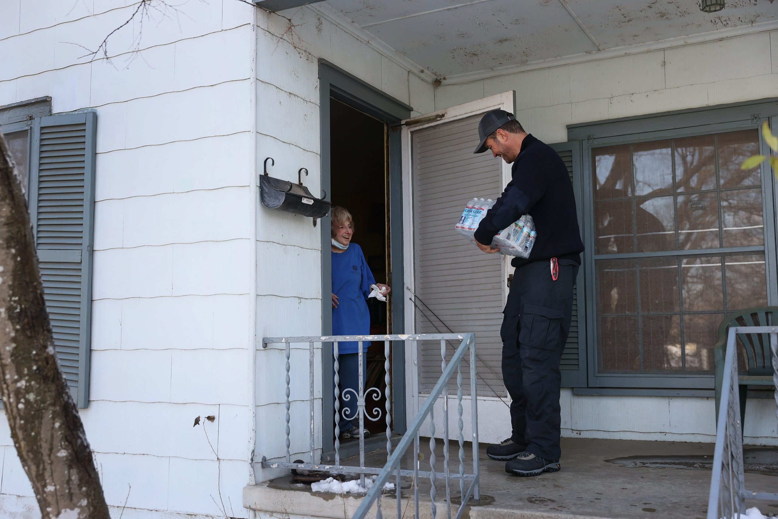Jason Parish, a volunteer with the Austin Disaster Relief Network, delivers water to Beth Placek on February 19, 2021 in Austin, Texas.