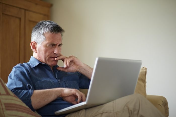 Man using laptop on sofa