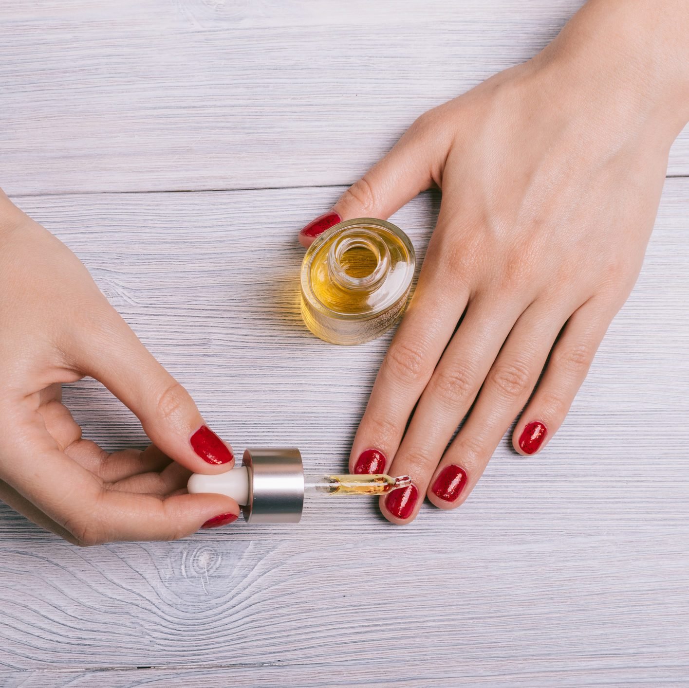 Female hand applied oil on the nails