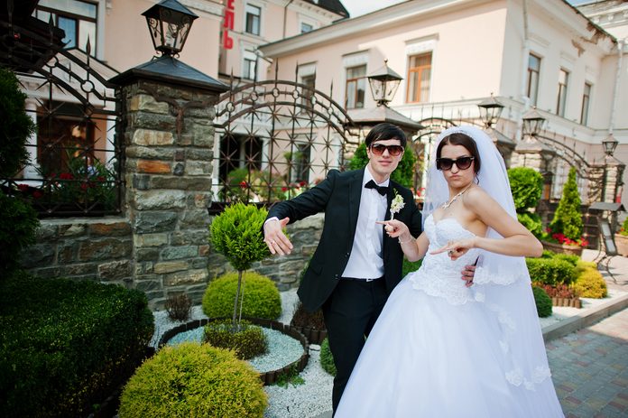 wedding couple with dark glasses and striking funny poses