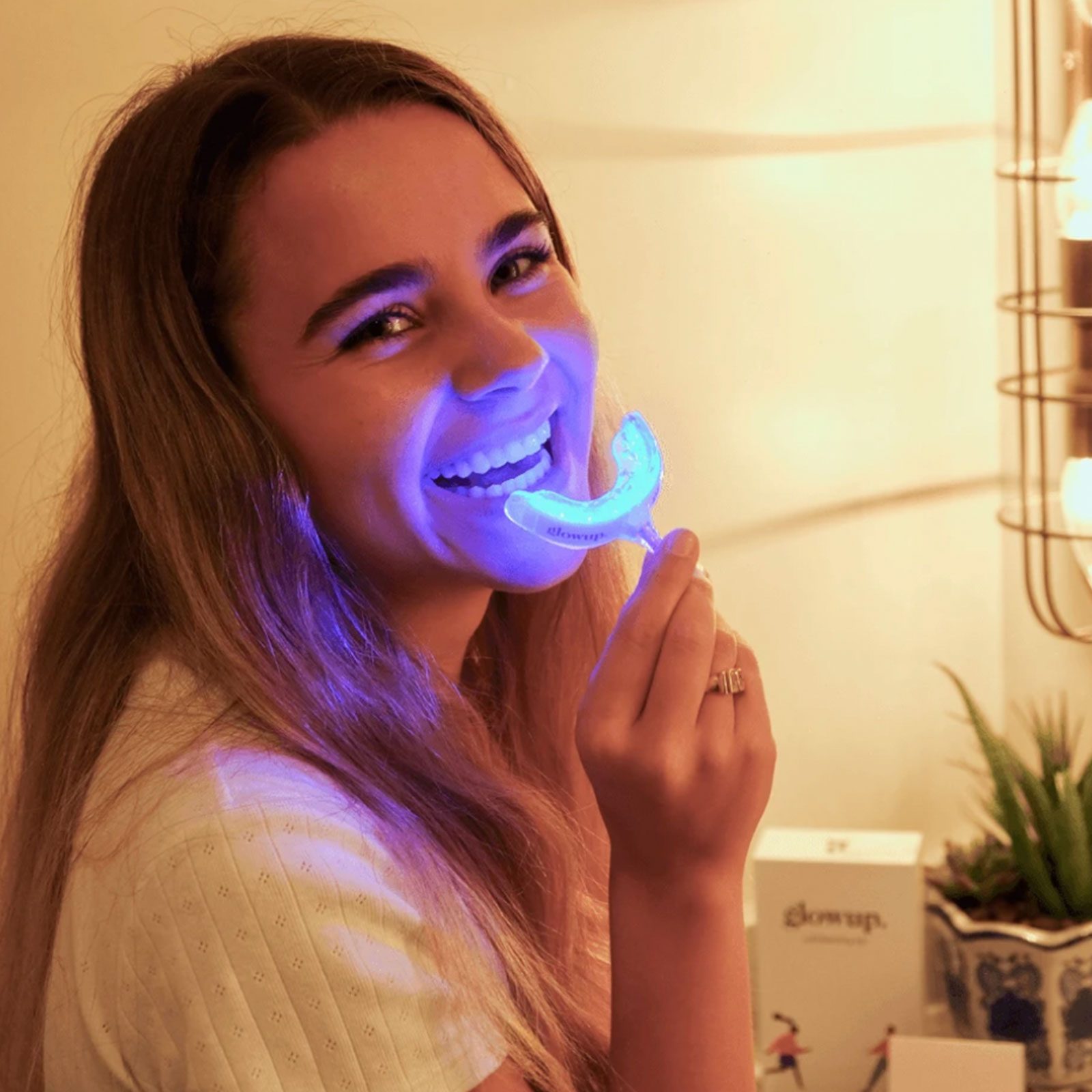 Woman whitening her teeth with Glowup