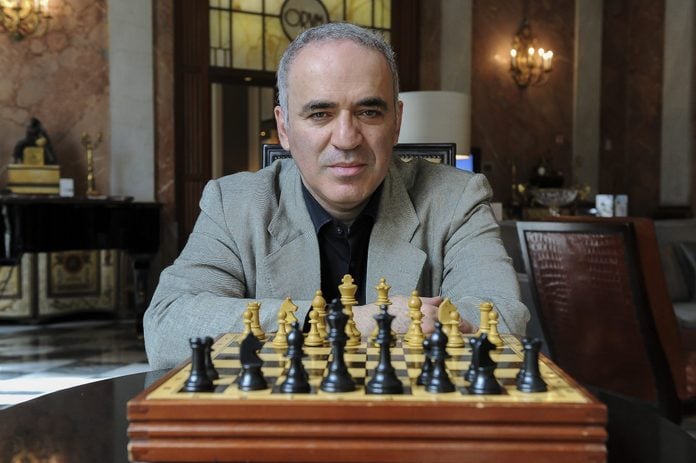 Garry Kasparov sitting with a chess board