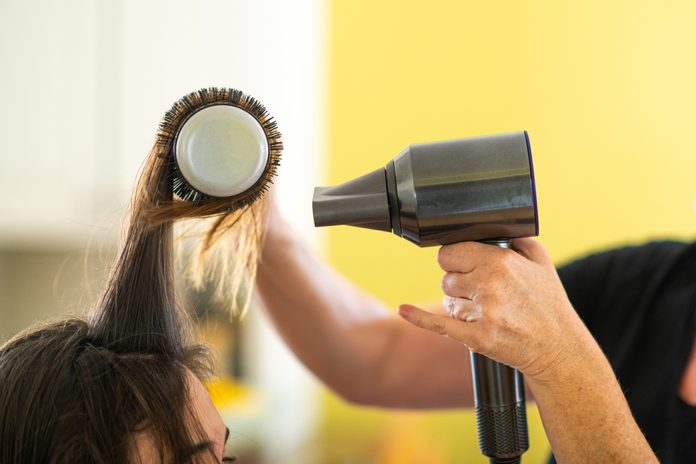 Hairdresser Blowdrying Her Clients Hair