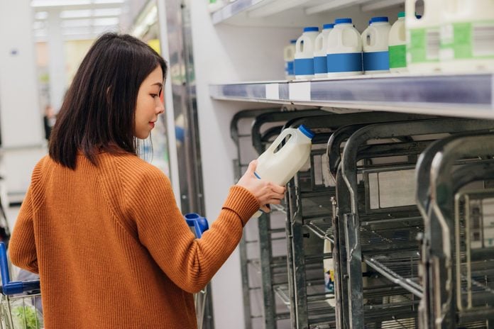 Young Asian woman shopping milk in grocery store