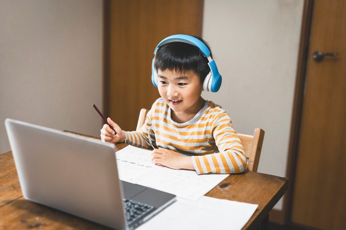 Boy wearing headset taking an e-Learning course with laptop