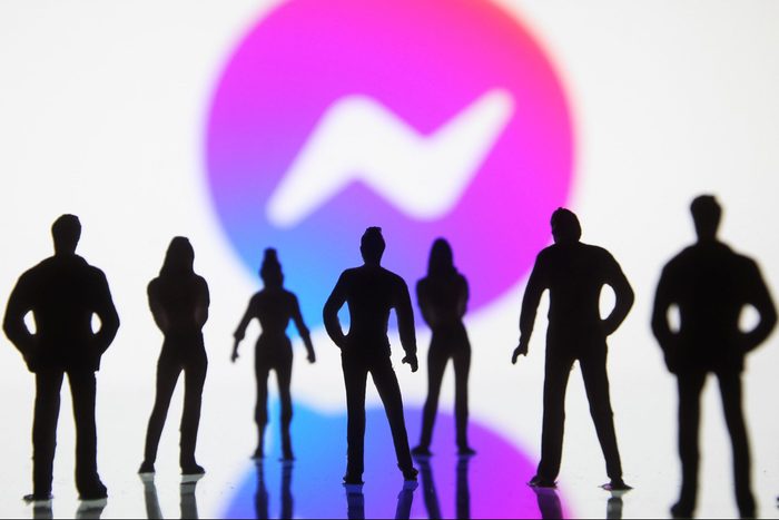silhouetted figures of toy people seen displayed in front of a Facebook Messenger logo