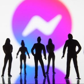 silhouetted figures of toy people seen displayed in front of a Facebook Messenger logo