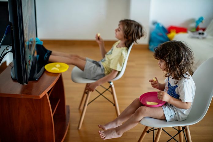 Kids eating in front of a television