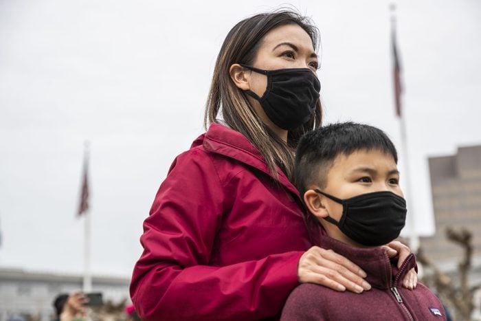 Minji Wong of San Francisco stands behind her nine-year-old son Miles while attending a "Love our People: Heal our Communities" rally at Civic Center Plaza in condemnation of the recent increase in violence towards the Asian American community around the Bay Area in San Francisco, California Sunday, Feb. 14, 2021.