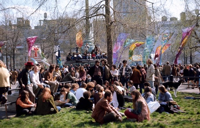 people gather in a park in New York City with banners to celebrate the first Earth Day, April 20, 1970