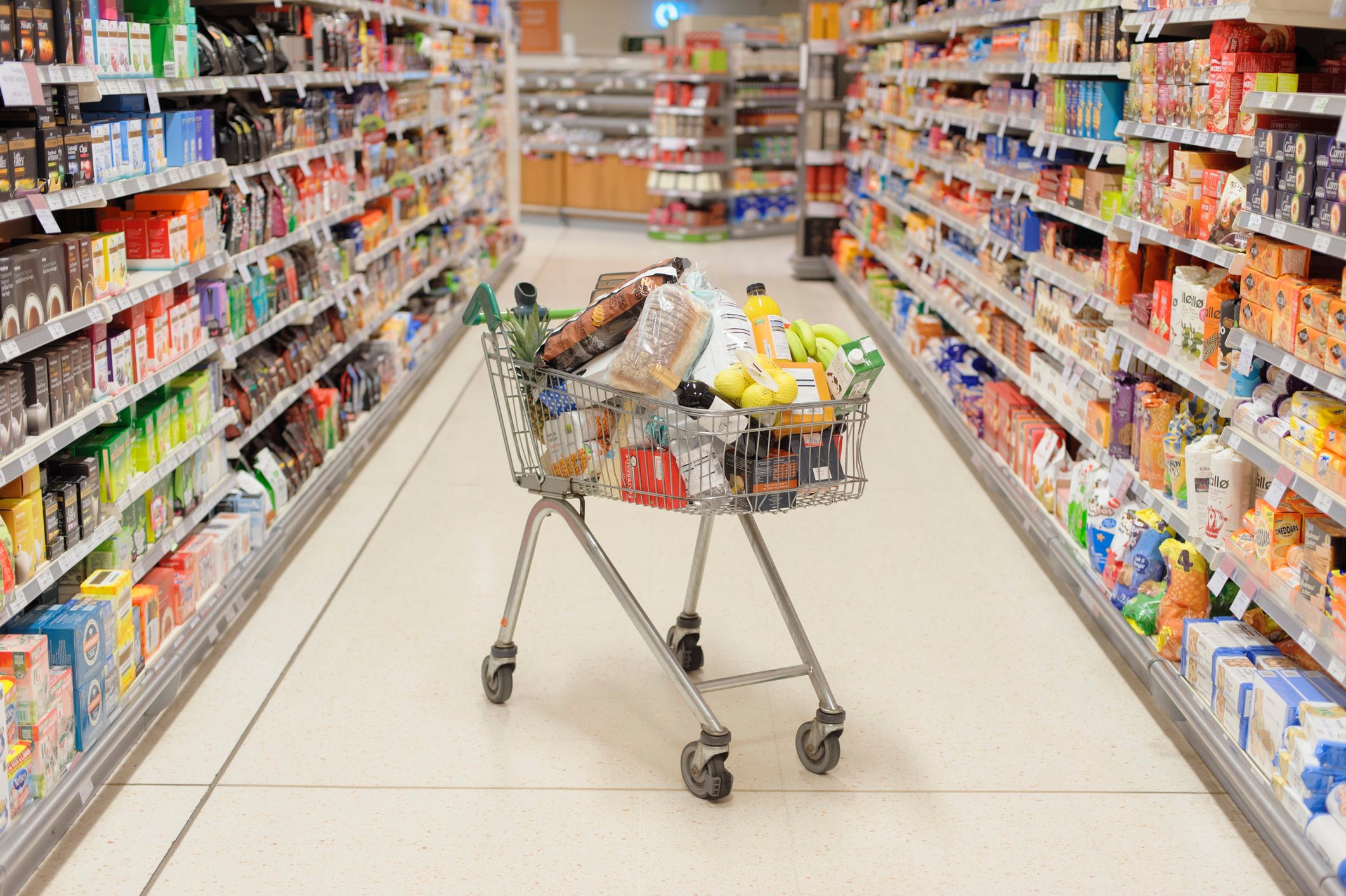 Full shopping cart in supermarket aisle