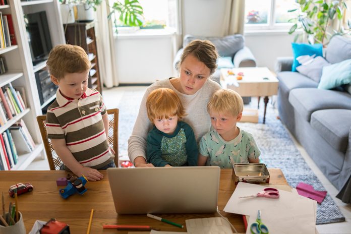 Female professional with three sons in home office
