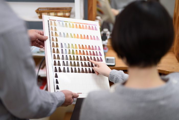 Female customer choosing hair color in hair salon