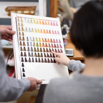 Female customer choosing hair color in hair salon