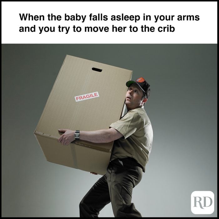 Delivery man holding large package. MEME TEXT: When the baby falls asleep in your arms and you try to move her to the crib