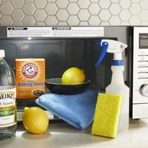 a microwave with cleaning products used to clean it