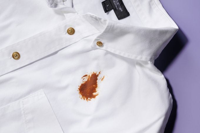 a chocolate stain on a white shirt on purple background