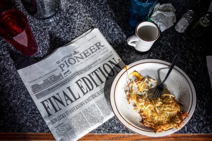 a newspaper with large letters "Final Edition" on the counter of a diner
