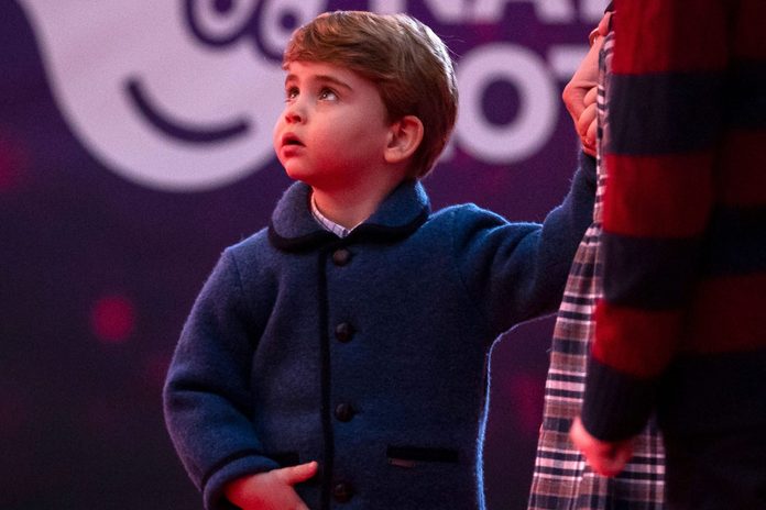 Britain's Prince Louis of Cambridge holds his mother's hand as they attend a special pantomime performance of The National Lotterys Pantoland at London's Palladium Theatre in London on December 11, 2020