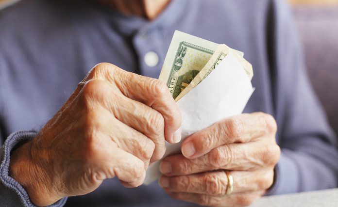 Senior Man Hands Holding Money and Breakfast Bill
