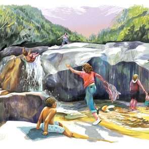 children play near a waterfall; mother runs towards her son as he falls
