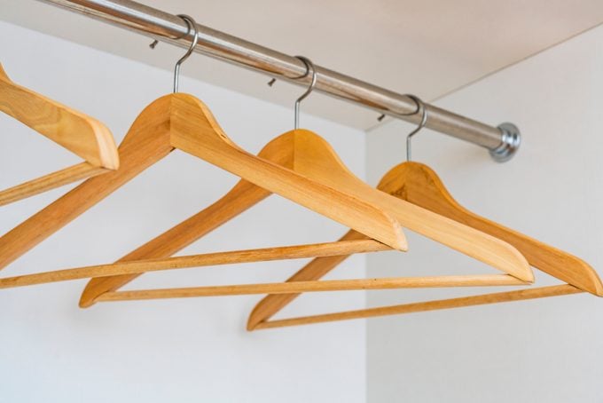 Wooden hangers on a rod in an empty closet