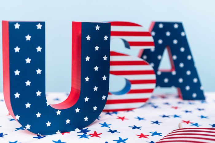 Red, white, and blue USA sign decorated with stripes and stars.