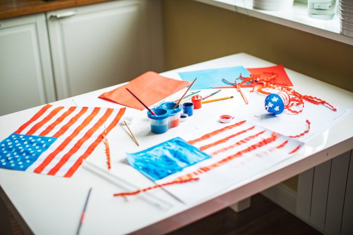 kids craft table with paints and paper and drawings of the american flag