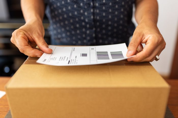 Woman preparing package for online delivery