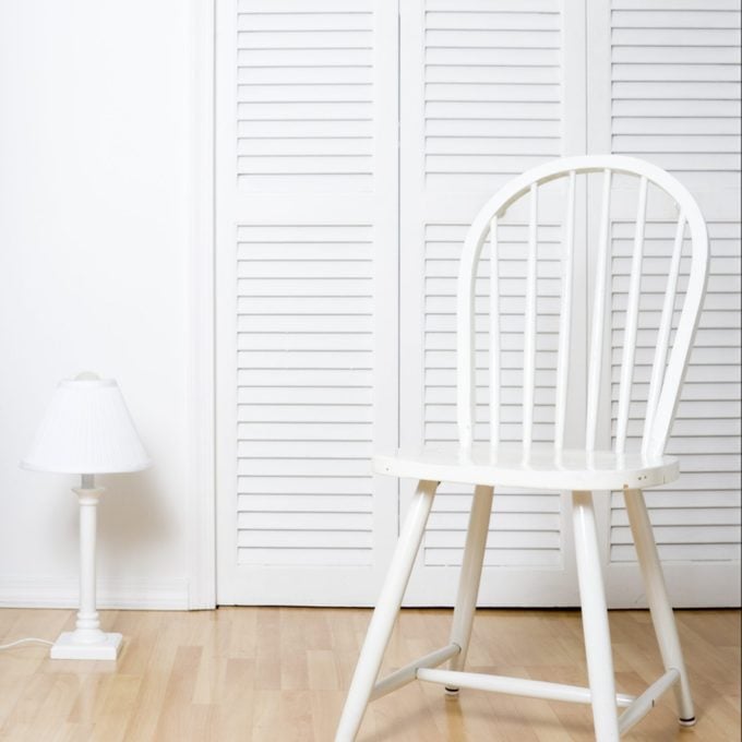 White chair and louvered closet doors