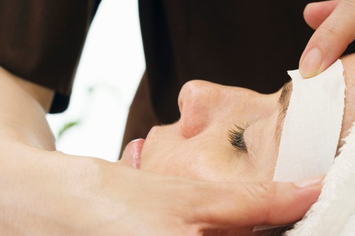 Woman having eye brows waxed, close-up