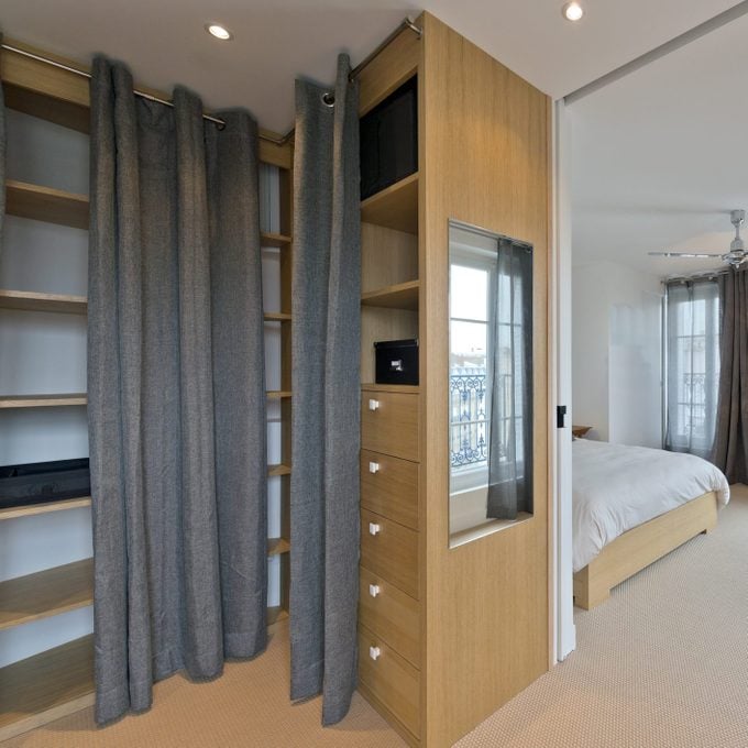 Modern bedroom interior with curtains as closet doors