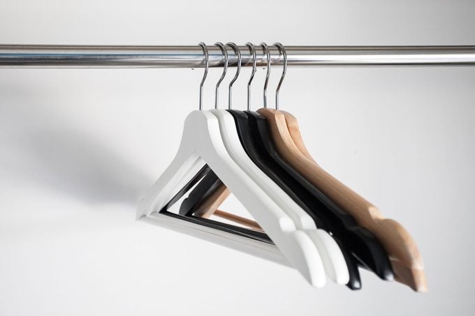 different types of hangers hanging in an empty closet
