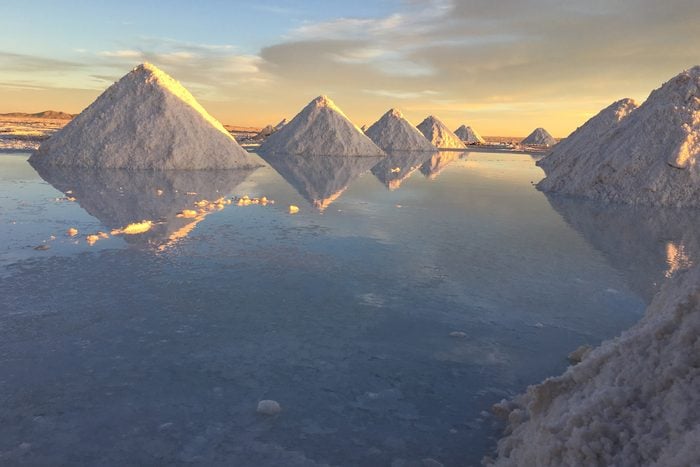 Salt By Calm Lake Against Sky At Salar De Uyuni in Bolivia