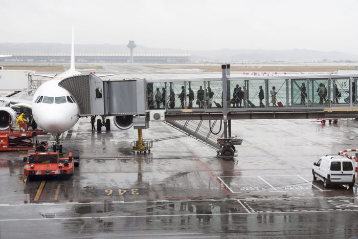 Passengers boarding an airplane through a boarding bridge