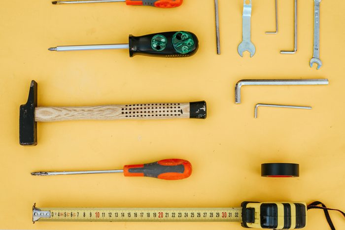 various hand tools for home improvement arranged on yellow background