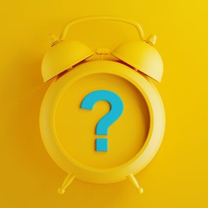 Yellow Alarm Clock with Blue Question Mark on Yellow Background