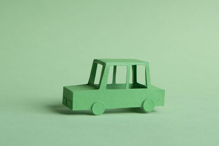 Paper car made of green paper on green background