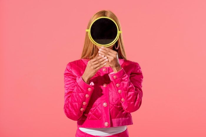 woman with a mirror on a pink background