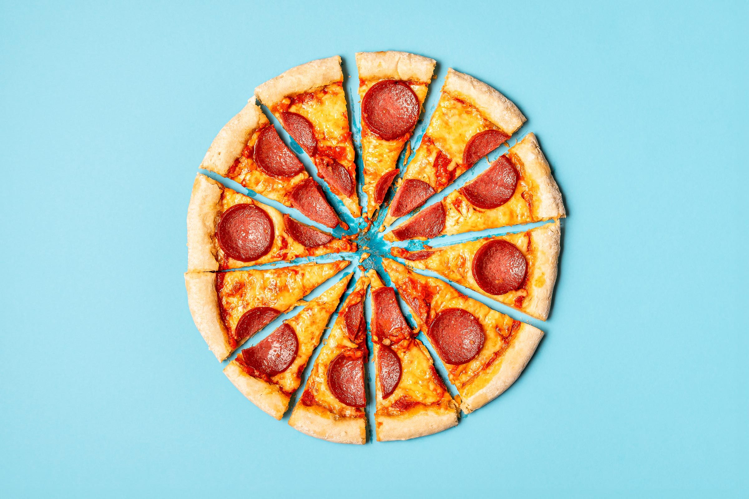 slices of pizza making a whole pizza on a blue background