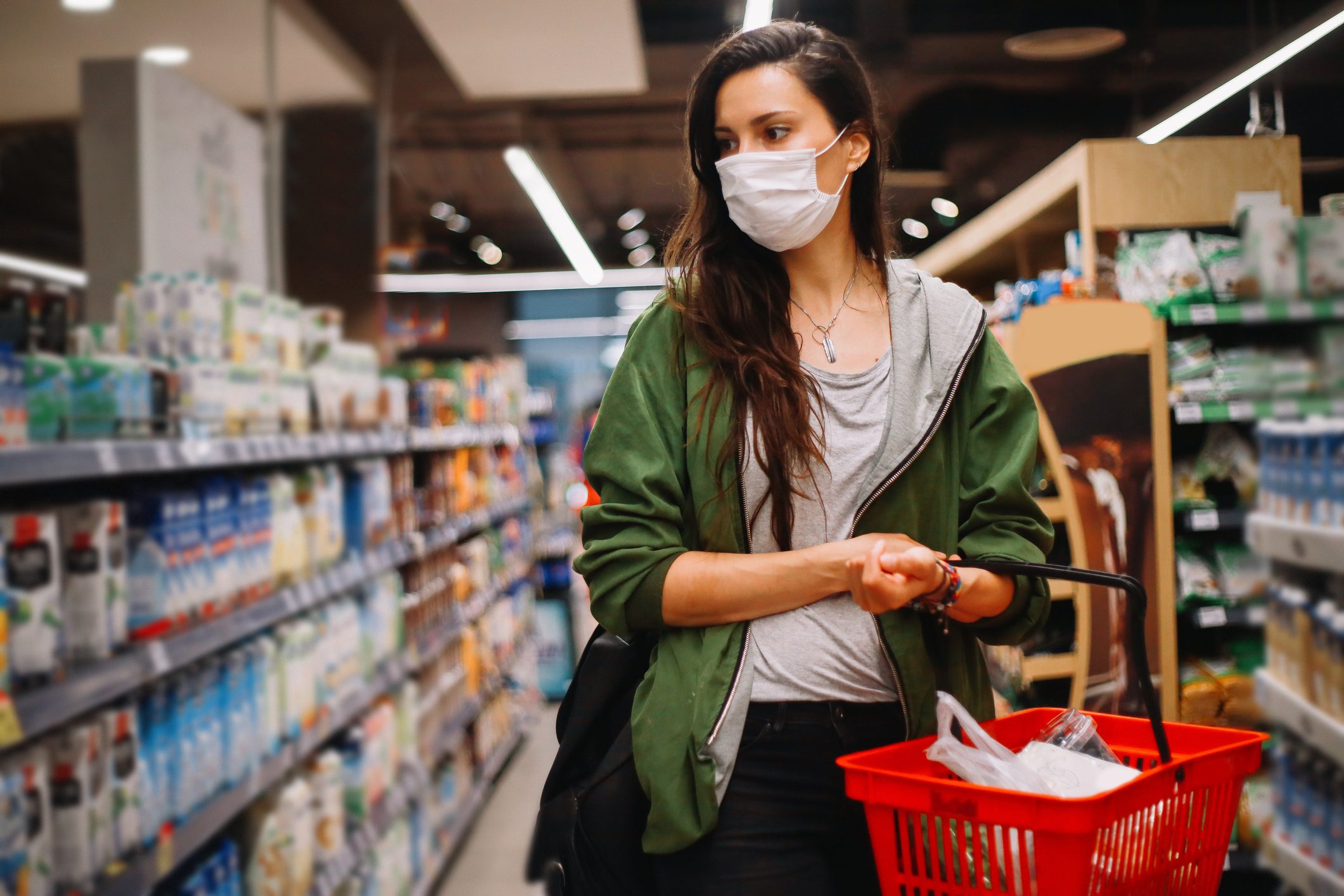 young woman shopping at a grocery store with a face mask