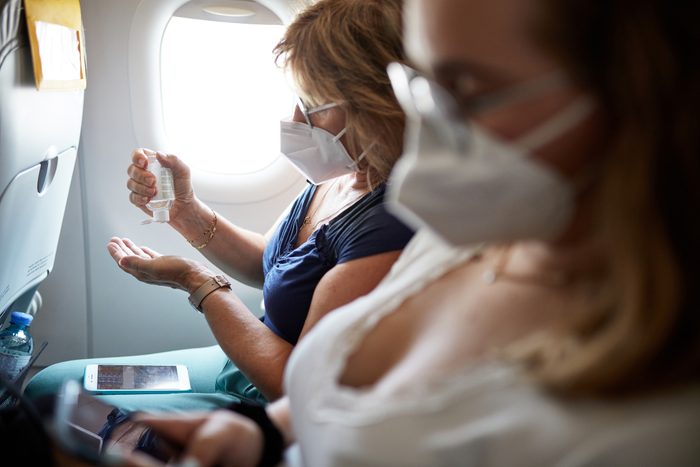 Mature Woman Using Hand Sanitizer During Airplane Trip