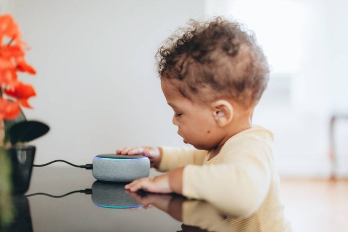 cute baby touching amazon alexa smart speaker device