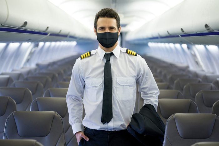 Pilot in an airplane wearing a facemask