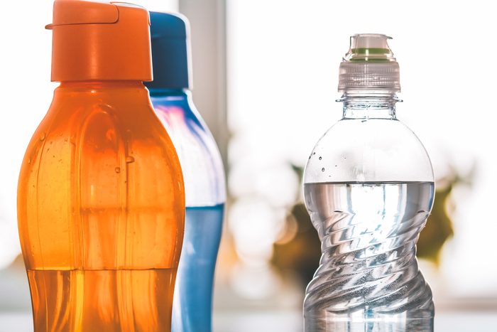 Several colored pet bottles with drinking water close-up. Polypropylene food products