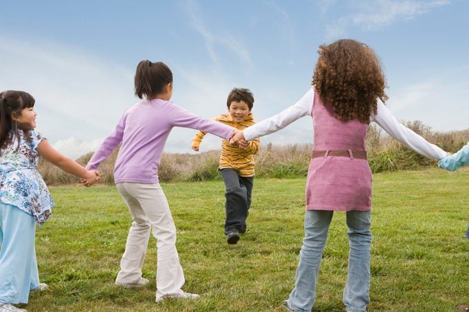 Multi Ethnic Children Playing Game In Field