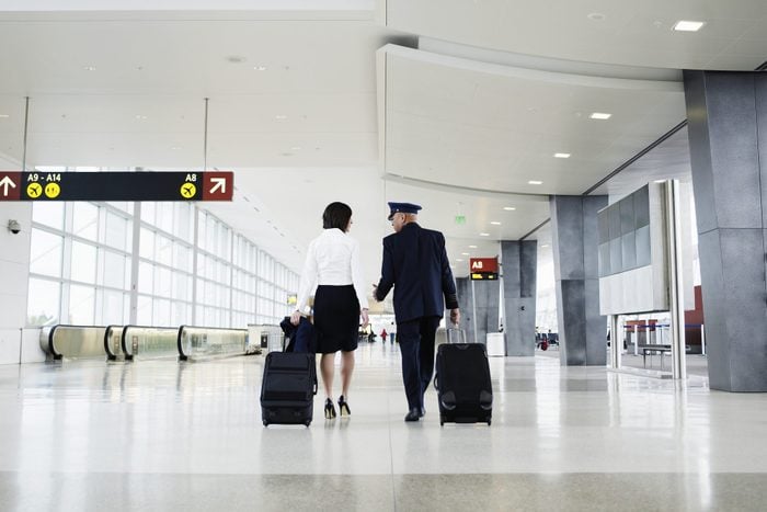 Pilot and flight attendant walking through airport