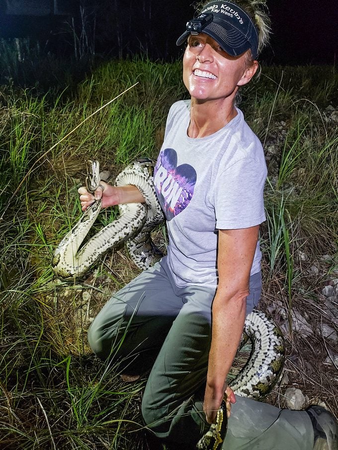 Amy Siewe smiling at camera with python in hand
