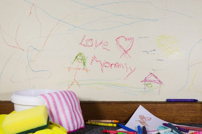 Child's crayon graffiti love mommy wall art drawing with crayons and cleaning material